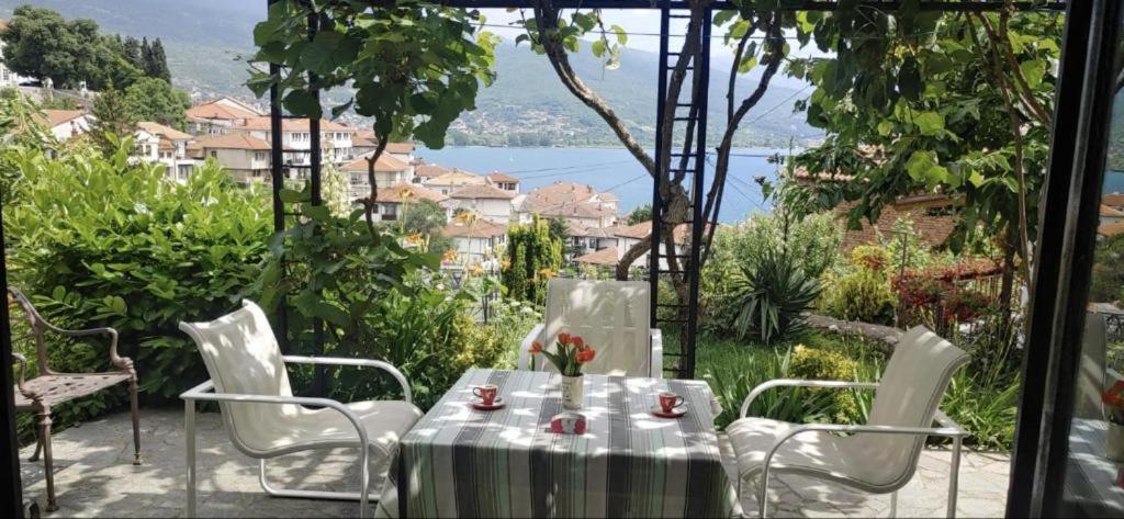 een tafel en stoelen met uitzicht op het water bij Tito's Place in Ohrid