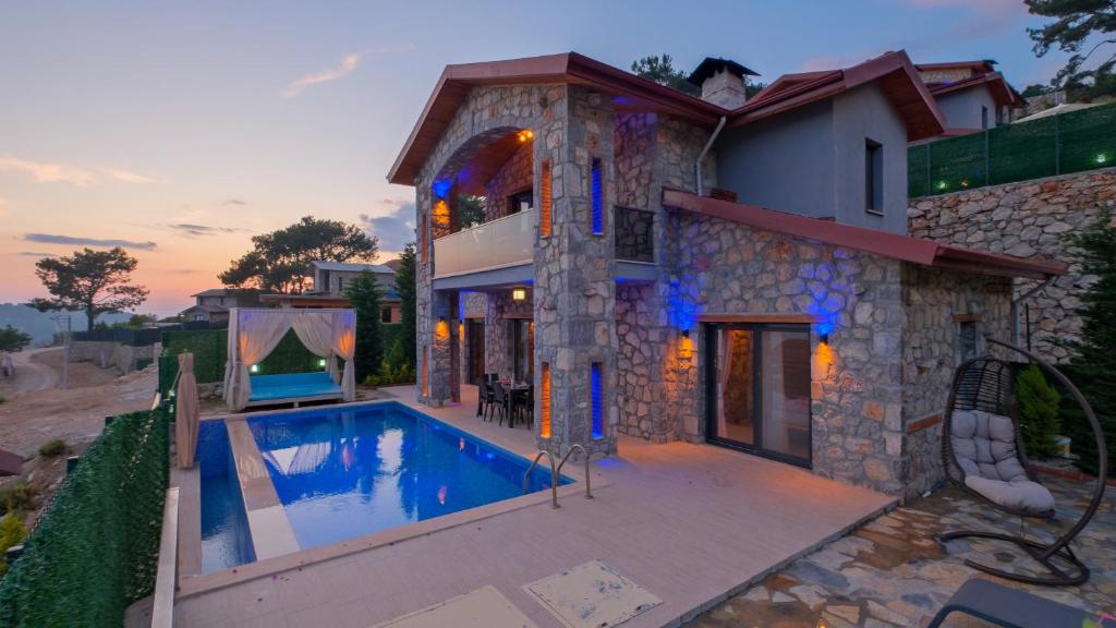 una casa con una piscina di fronte di VİLLA VAVEYLA a Oludeniz