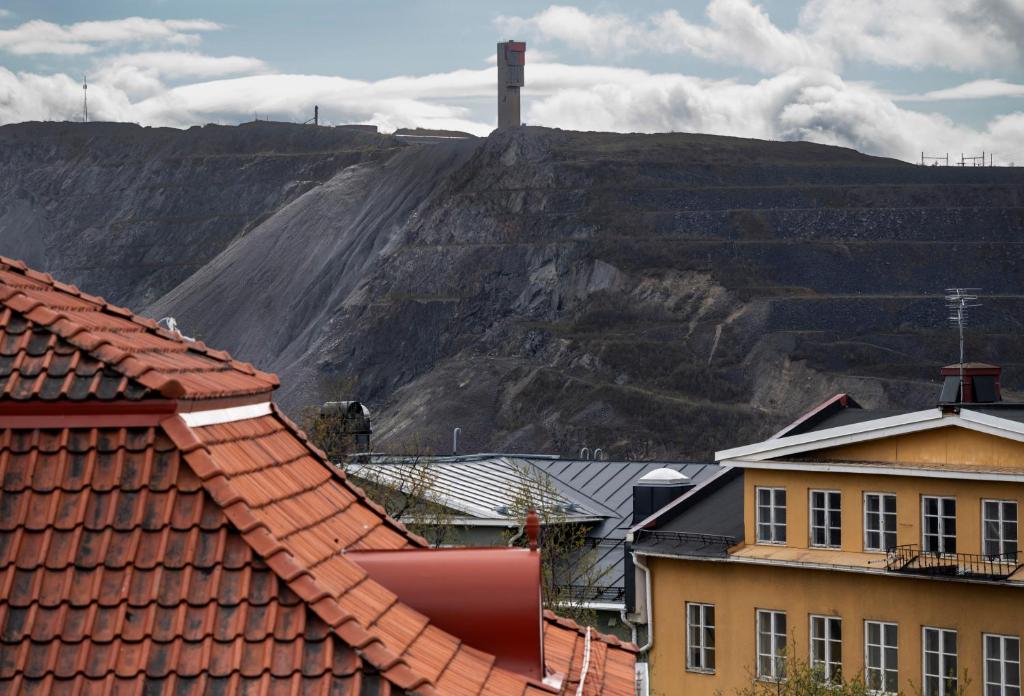 a view of a mountain from roofs of buildings at Hotel Bishops Arms Kiruna in Kiruna
