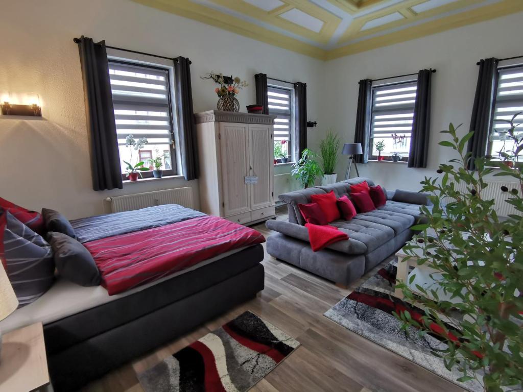 - un salon avec un canapé, un lit et des fenêtres dans l'établissement Ferienwohnung La Finesse, à Bad Salzungen