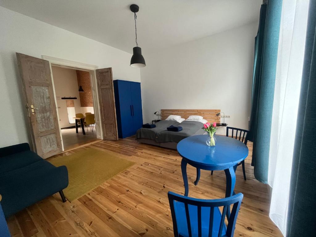 sala de estar con mesa azul y cama en Várkerület 6 Apartman, en Sárvár