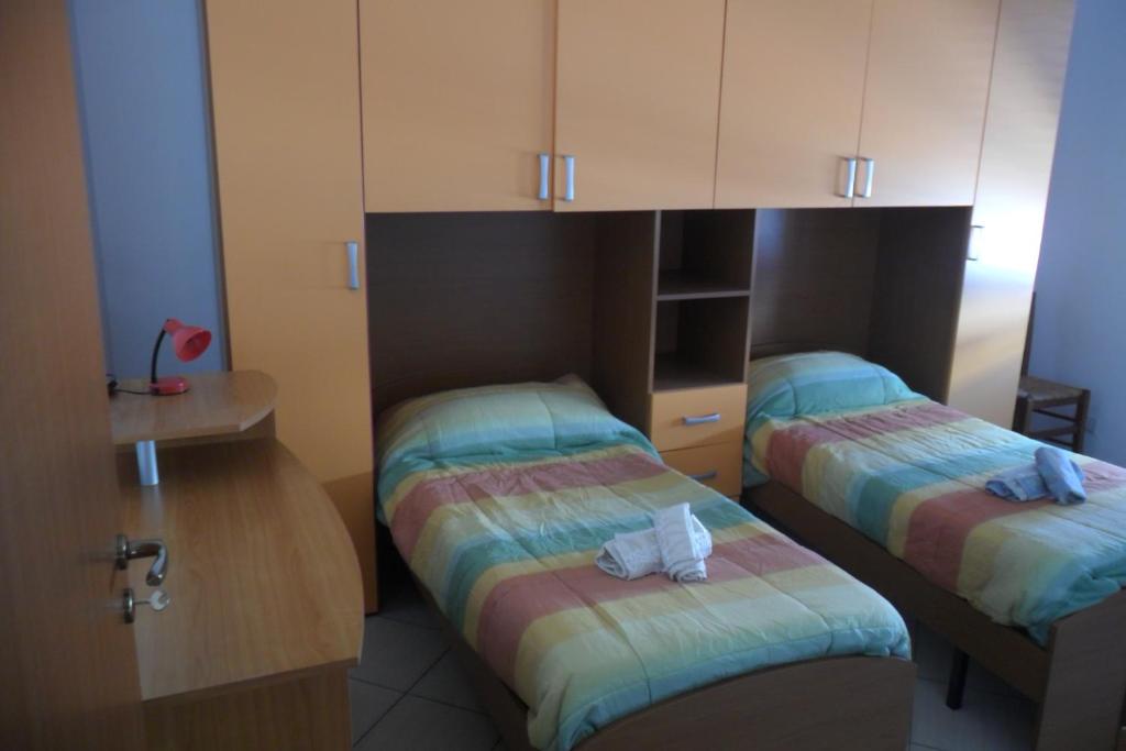 Zimmer mit 2 Betten und Schränken mit Handtüchern in der Unterkunft Valderice Vacanze for family in Valderice
