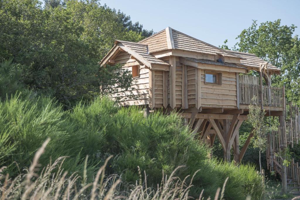 a tree house with a deck on top of a hill at Dihan Evasion in Ploemel