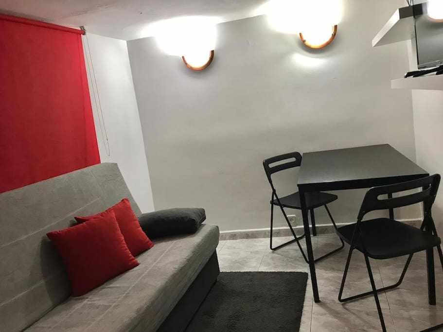 マドリードにあるAgradable apartamento en zona Malasaña Madridのリビングルーム(ソファ、テーブル付)