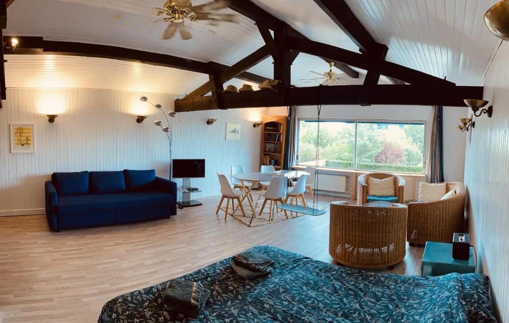 un salon avec un canapé bleu et une table dans l'établissement Chocolatine, le loft qui donne plus de chocolat! Moulleau, Pyla-sur-Mer, à Pyla-sur-Mer