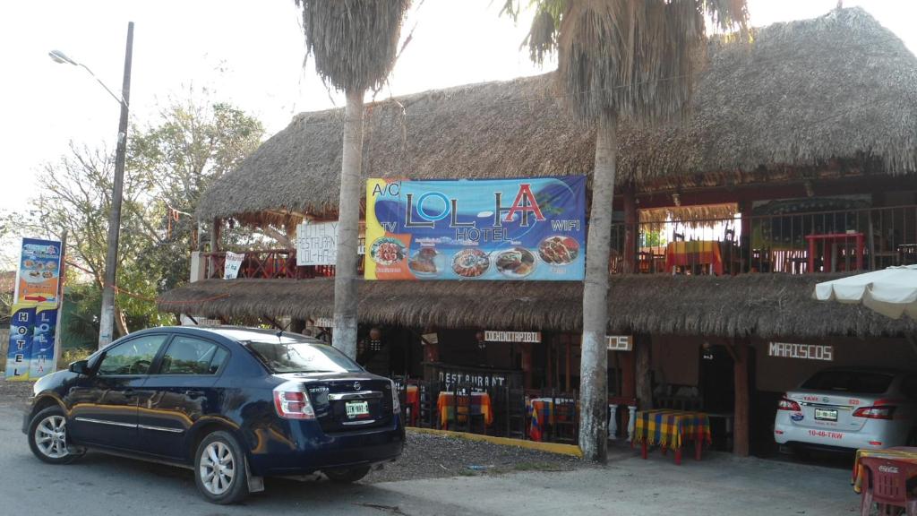 un pequeño coche aparcado frente a un restaurante en Hotel LOL-HA, en Cobá