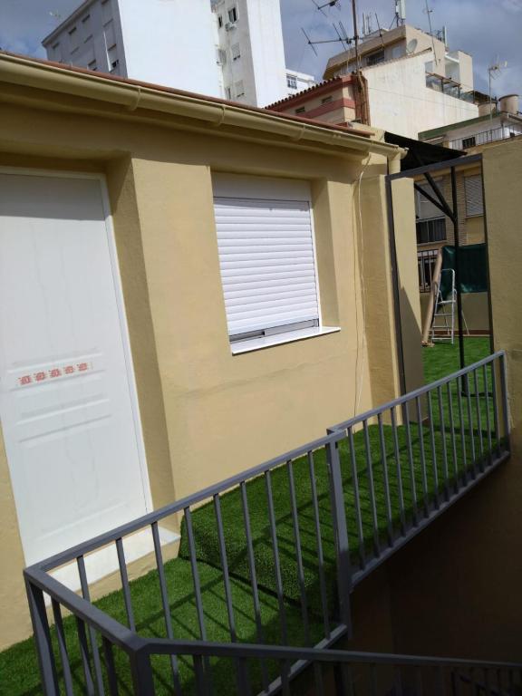 a house with two garage doors and a balcony at Appartment as a Service - Lo Mejor en Malaga Centro - Look no Further and Just Book in Málaga