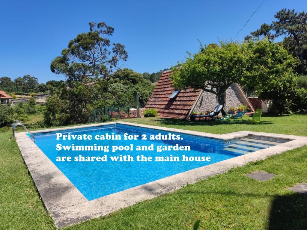 a sign for a swimming pool and garden are shared with the main house at Cabaña con piscina in Baiona