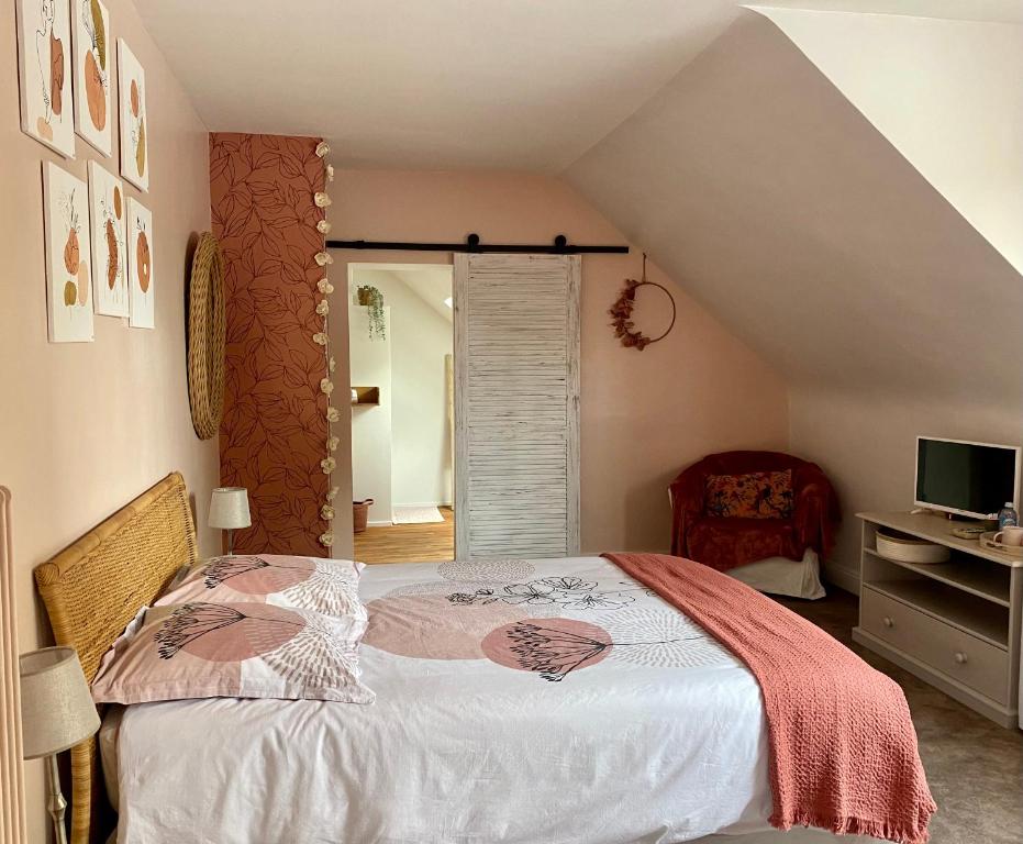 a bedroom with a bed and a desk with a television at Douce Halte in Sautron