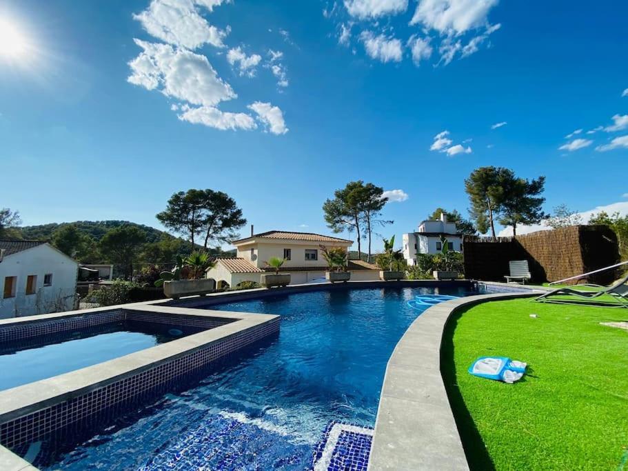 バルセロナにあるContempory exclusive Sitges areaの芝生の庭のある裏庭のスイミングプール