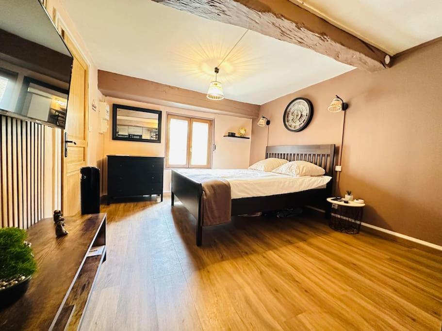 une chambre avec un lit et une horloge au mur dans l'établissement Le Refuge, à Laon