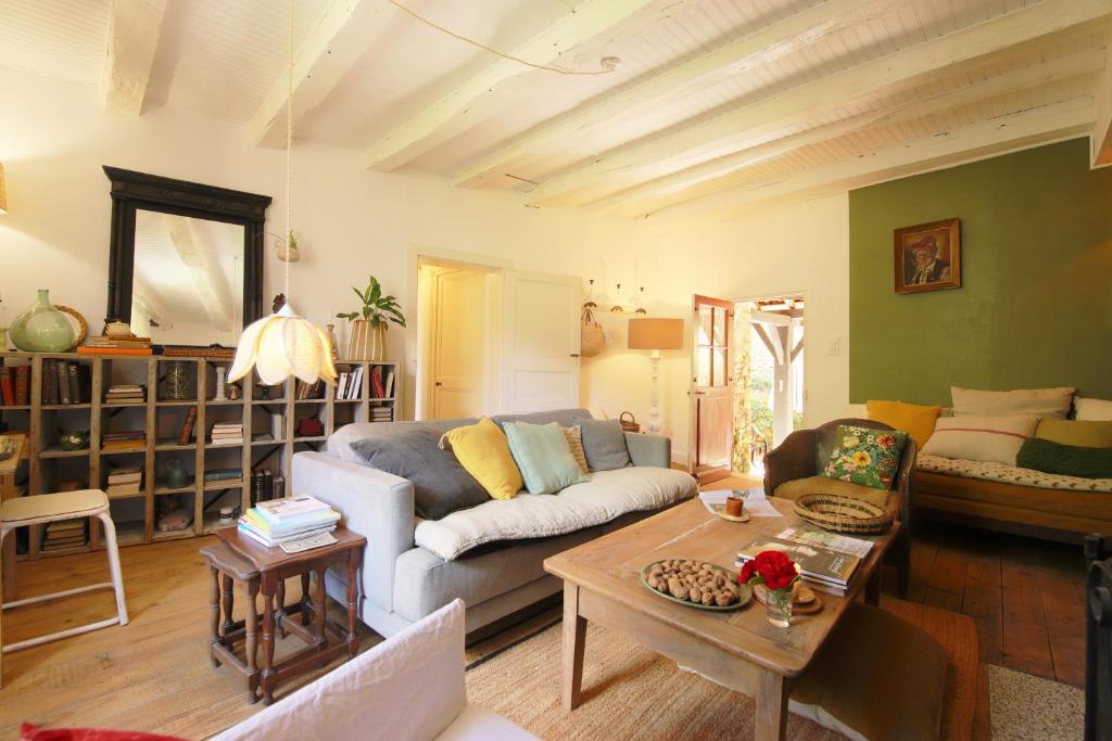 ein Wohnzimmer mit einem Sofa und einem Tisch in der Unterkunft La Maisonnette de La Jolie Vie in Urval