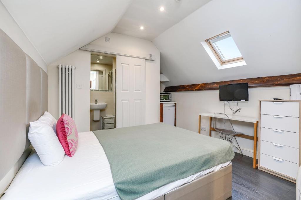 a bedroom with a bed and a desk and a television at Quiet Double Studio Flat in London