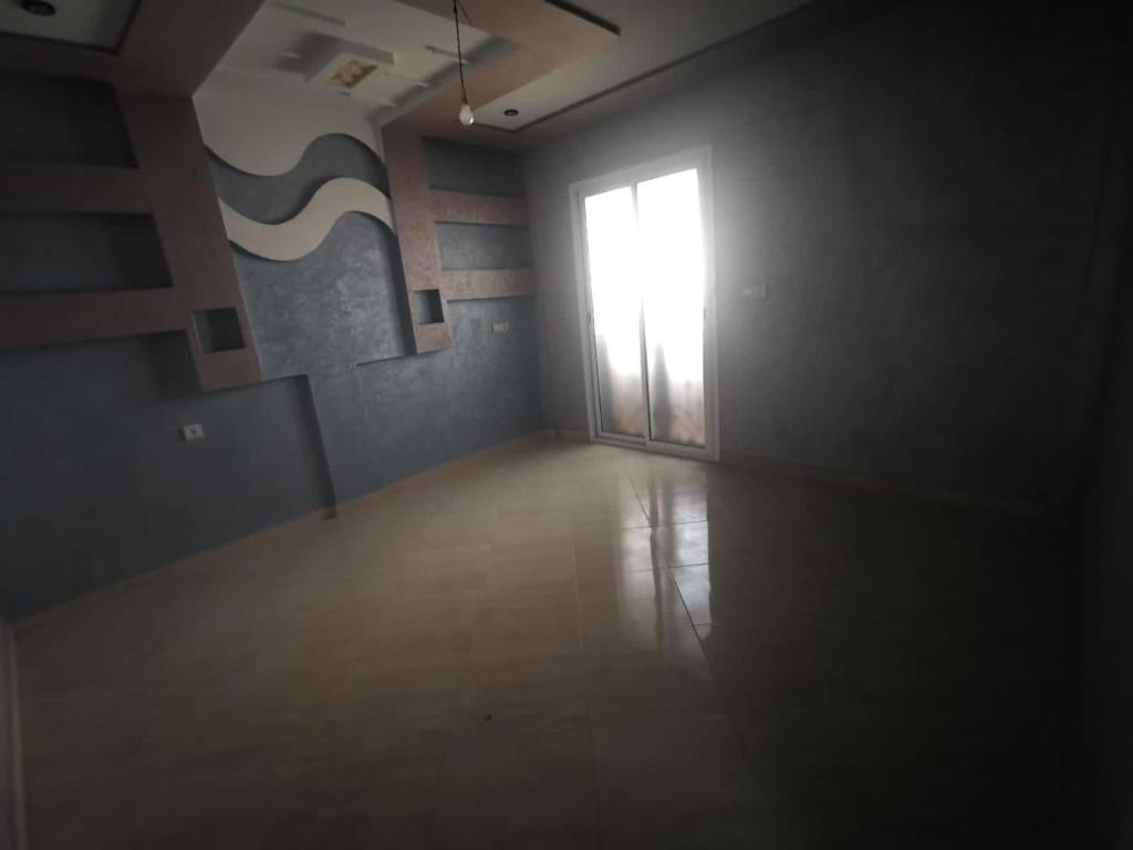 ein leeres Zimmer mit einer Tür und einem Fenster in der Unterkunft Chatif in Agadir