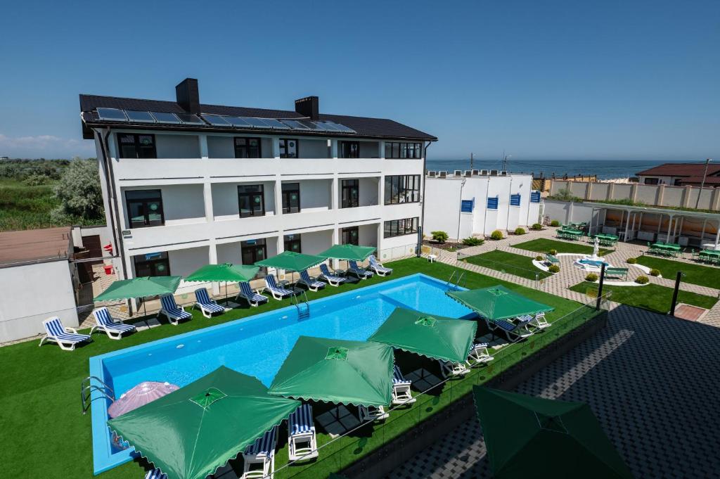 an aerial view of a hotel with a swimming pool and green umbrellas at Weekend Family Hotel in Karolino-Buhaz