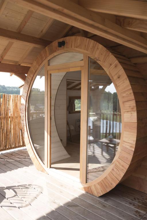 a circular wooden building with a round window on a deck at Dihan Evasion in Ploemel