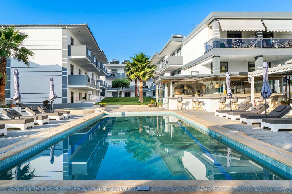 a swimming pool in front of a building at Akritas Hotel Pefkochori in Pefkochori