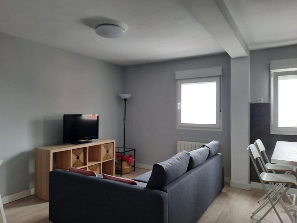 een woonkamer met een bank en een televisie bij Bonito Piso en Santander in Santander