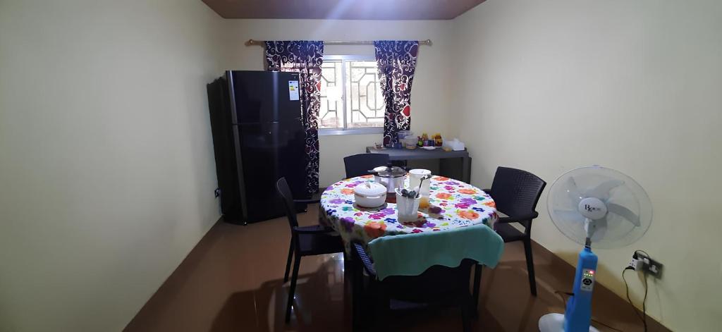 Una habitación con una mesa con un pastel. en Yogi Home Stay Near Freetown Airport en Freetown