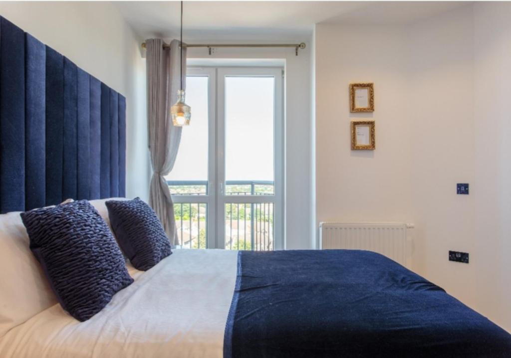 una camera da letto con un letto e una grande finestra di Light Airy Double Short walk from Elizabeth Line a Goodmayes