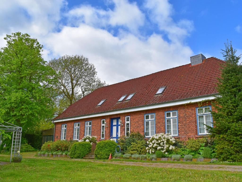 a red brick house with a red roof at Apartment in Schultenbrook with garden in Metelsdorf