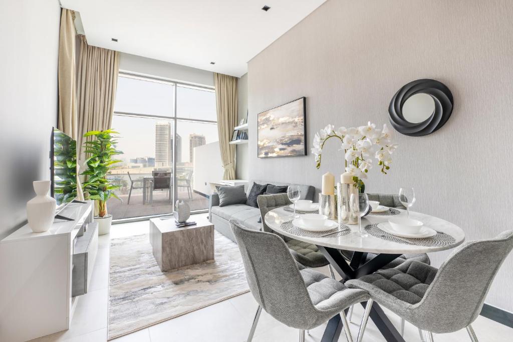 uma sala de estar com uma mesa e cadeiras e um sofá em Downtown Ultra Luxury 1BR - 15 Northside - Burj Khalifa View no Dubai