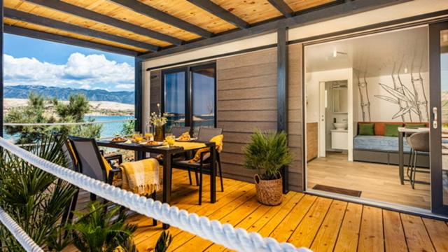 patio con tavolo e sedie su una terrazza in legno di Terra Park SpiritoS - Luxury mobile house Ina a Kolan