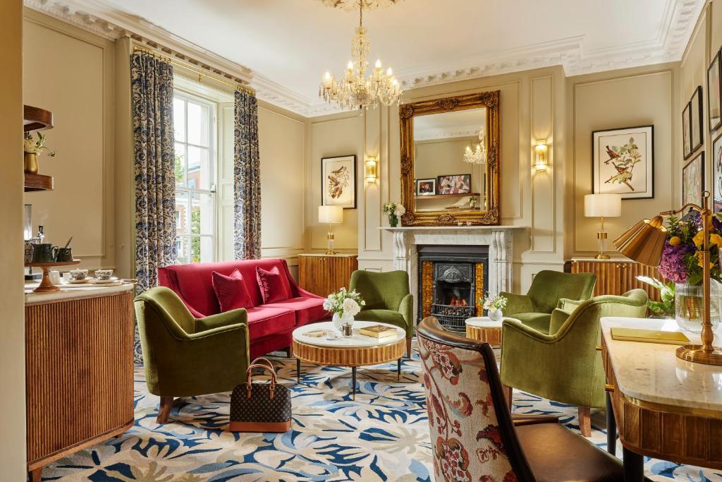 a living room with green chairs and a fireplace at Waterloo Town House & Suites in Dublin