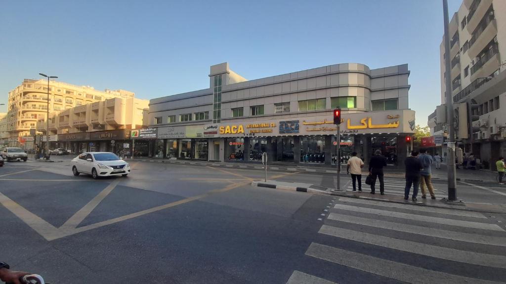 a busy city street with a white car on a crosswalk at KMB Double-bed Room at union metro in Dubai