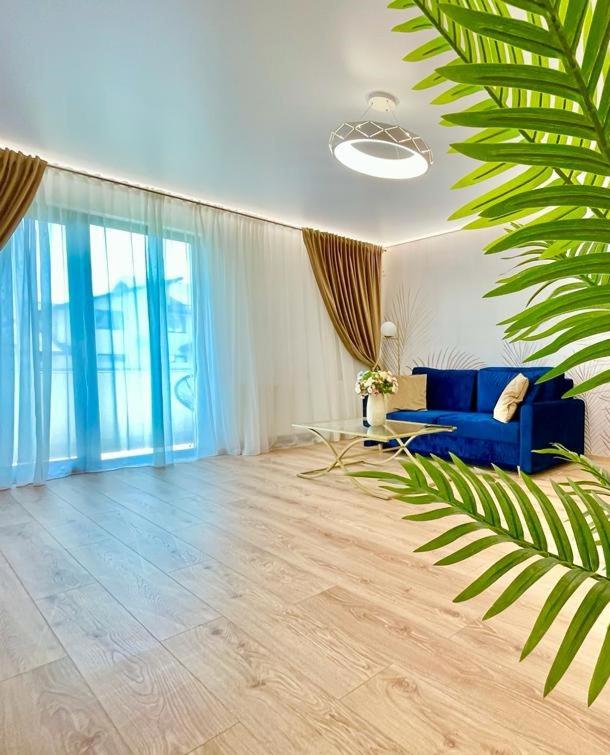 a living room with a blue couch and some windows at Residence Odaile #2 in Otopeni