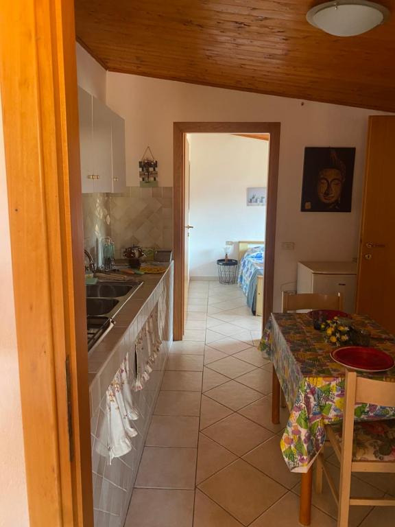 uma cozinha com um balcão e uma mesa num quarto em Casa Giola em Solanas