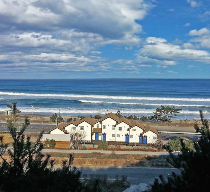 a row of houses in front of the ocean at Amigas Ocean View Pension in Yangyang