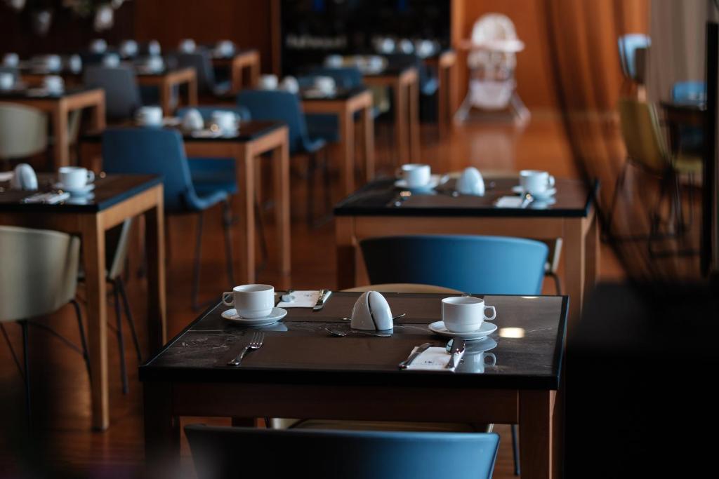 a dining room with tables and blue chairs at Eurostars Queen of Montenegro in Budva
