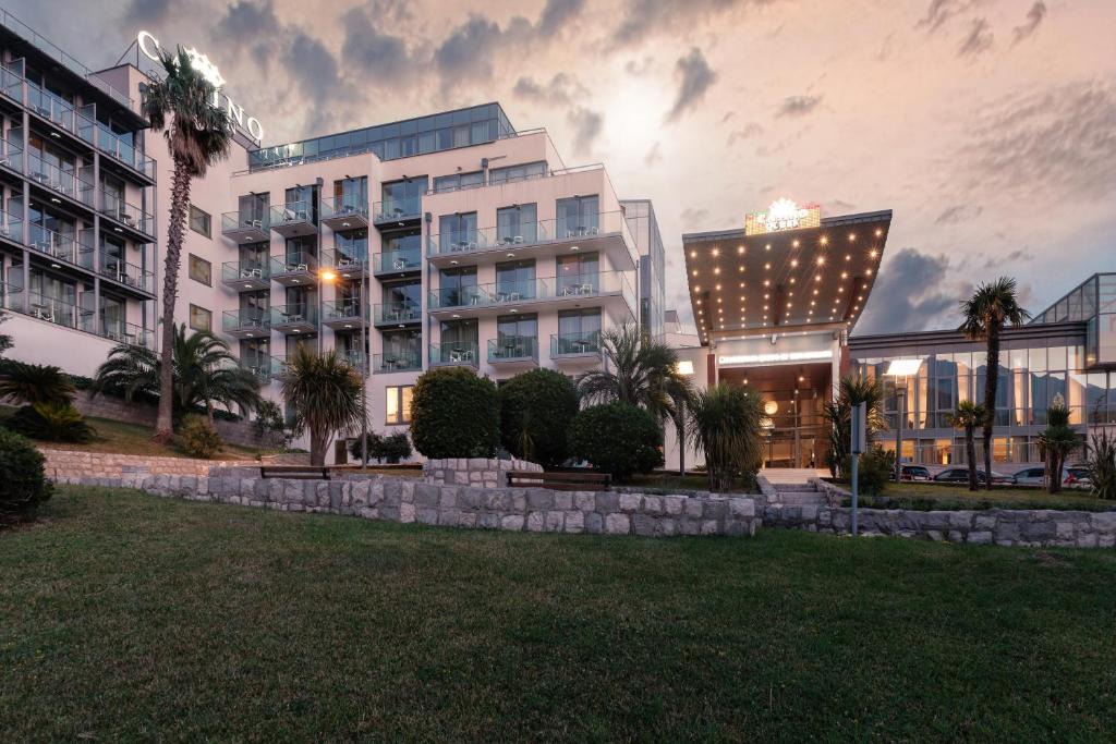 a large building with palm trees in front of it at Eurostars Queen of Montenegro in Budva