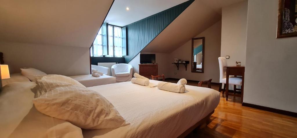 1 dormitorio con 1 cama blanca grande con almohadas en Casa de Aldea Las 7 gotas, en Celorio