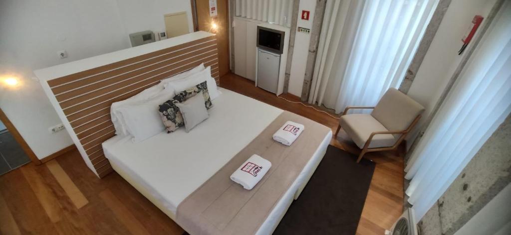 una vista sul soffitto di una camera da letto con un letto e una sedia di Stay in Apartments - S. Bento a Porto