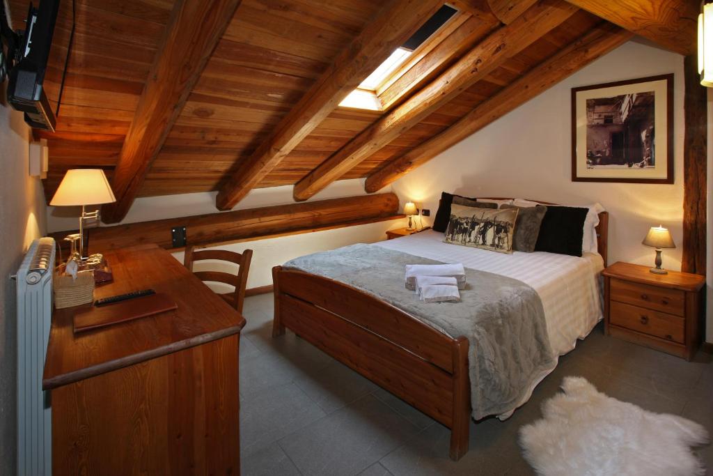 a bedroom with a bed and a wooden ceiling at Chalet Faure in Sauze dʼOulx