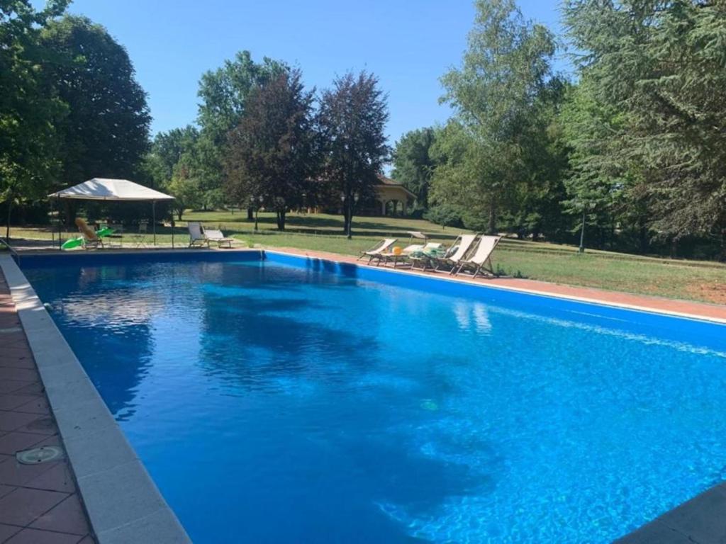 een groot zwembad met blauw water in een tuin bij Villa Di Lambda in Cellarengo