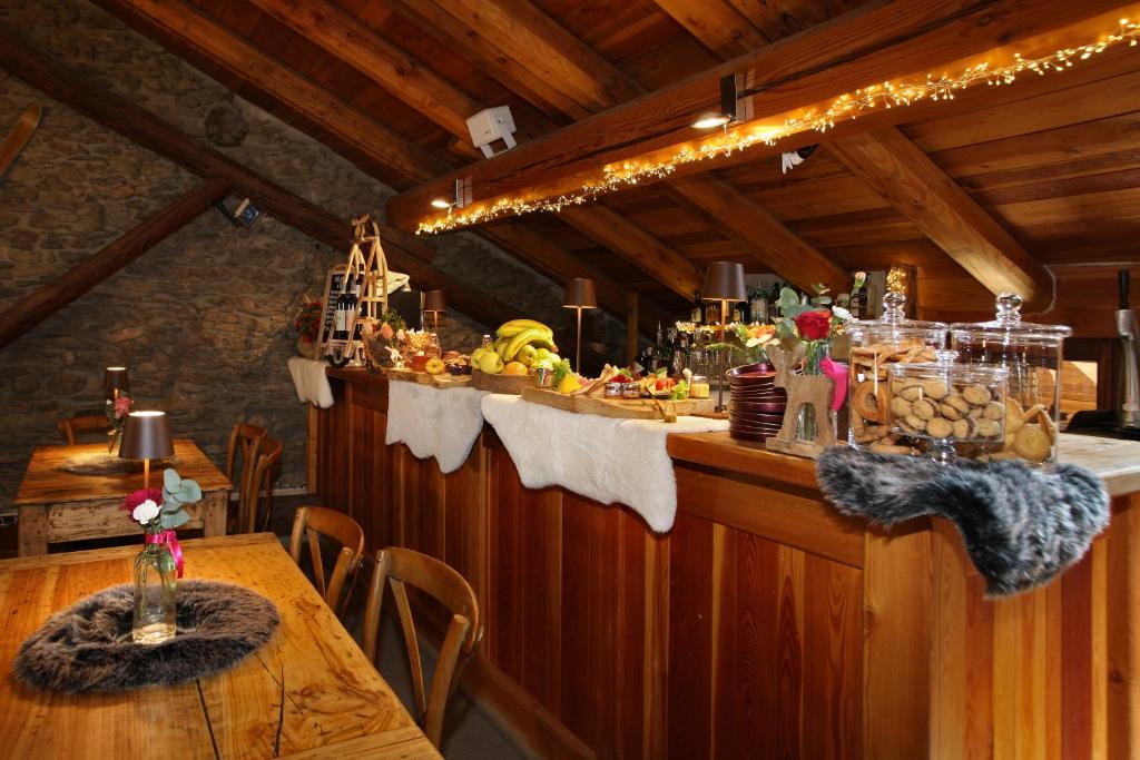 a restaurant with a bar with a table with food at Chalet Faure in Sauze dʼOulx