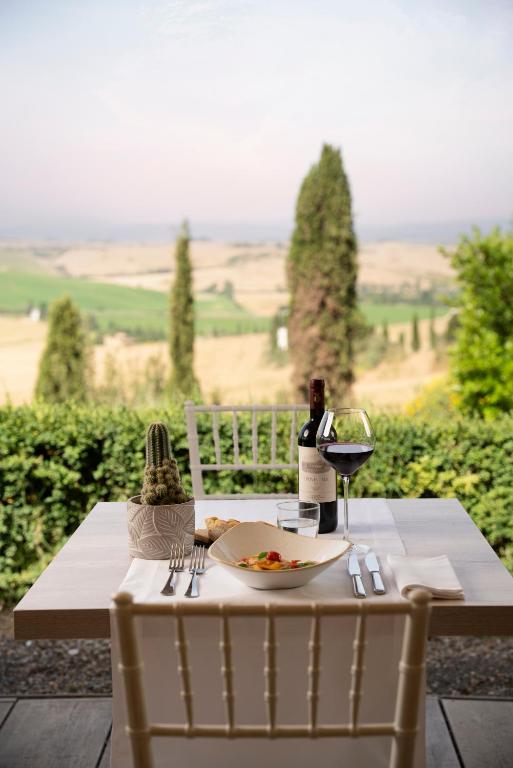 stół z talerzem jedzenia i kieliszkiem wina w obiekcie Castello di Leonina Relais - Adults Only w Sienie