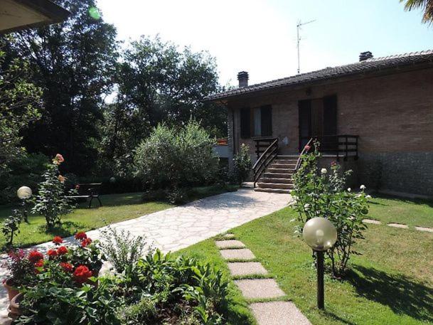 ein Haus mit einem Garten mit Blumen im Hof in der Unterkunft Il Boschetto in Le Grazie