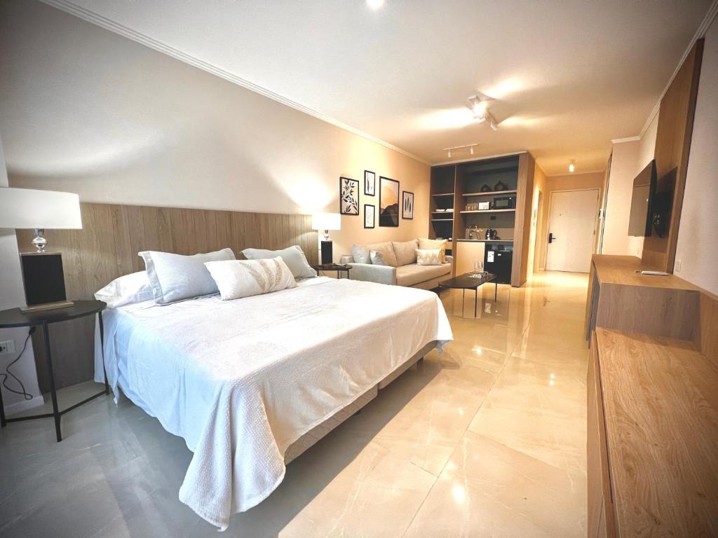 ブエノスアイレスにあるLuxury Apartments in Deco Recoleta by Apartments Barilocheのベッドルーム(大きな白いベッド1台付)、リビングルームが備わります。