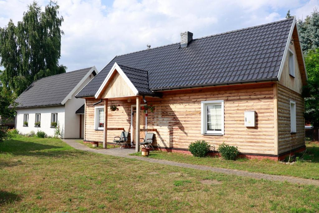 a wooden house with a black roof at Agroturystyka u Koziołka in Długowola