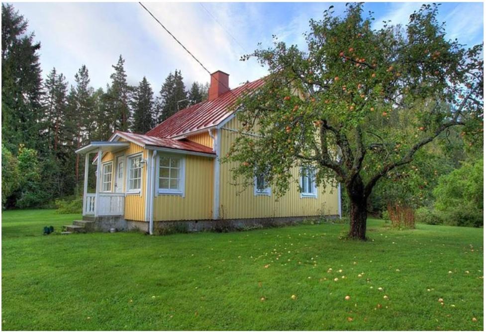 uma casa amarela com uma árvore no quintal em Norrby Gård - Sjövik em Raseborg