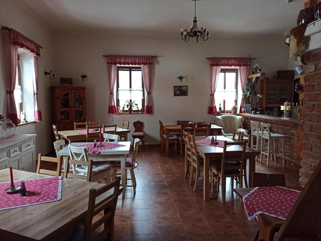 un comedor con mesas, sillas y ventanas en Hospůdka Na Trucovně en Sázava