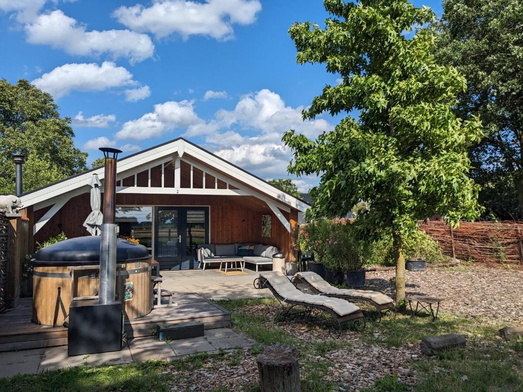 une maison avec un poêle à bois dans la cour dans l'établissement Chalet "Het Biggetje" met hottub, à Volkel