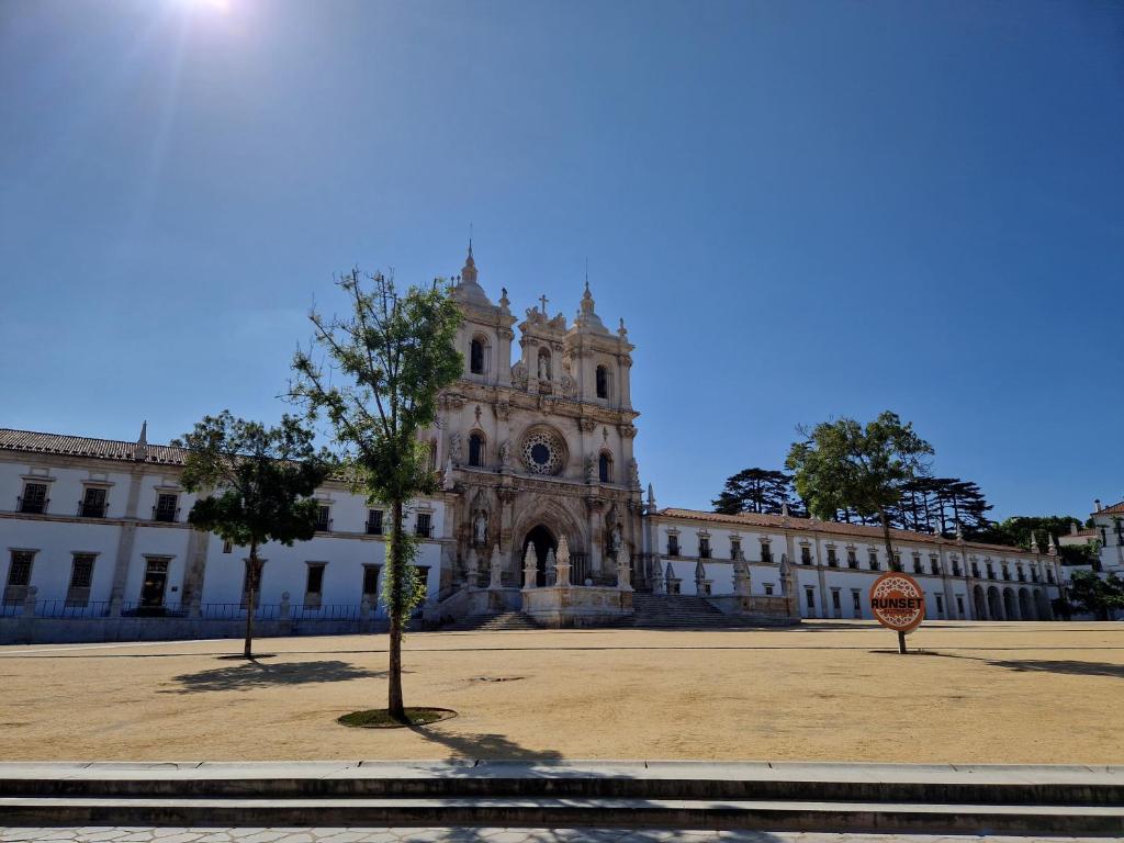 a large building with a clock tower in front of it at Casa Mosteiro in Alcobaça