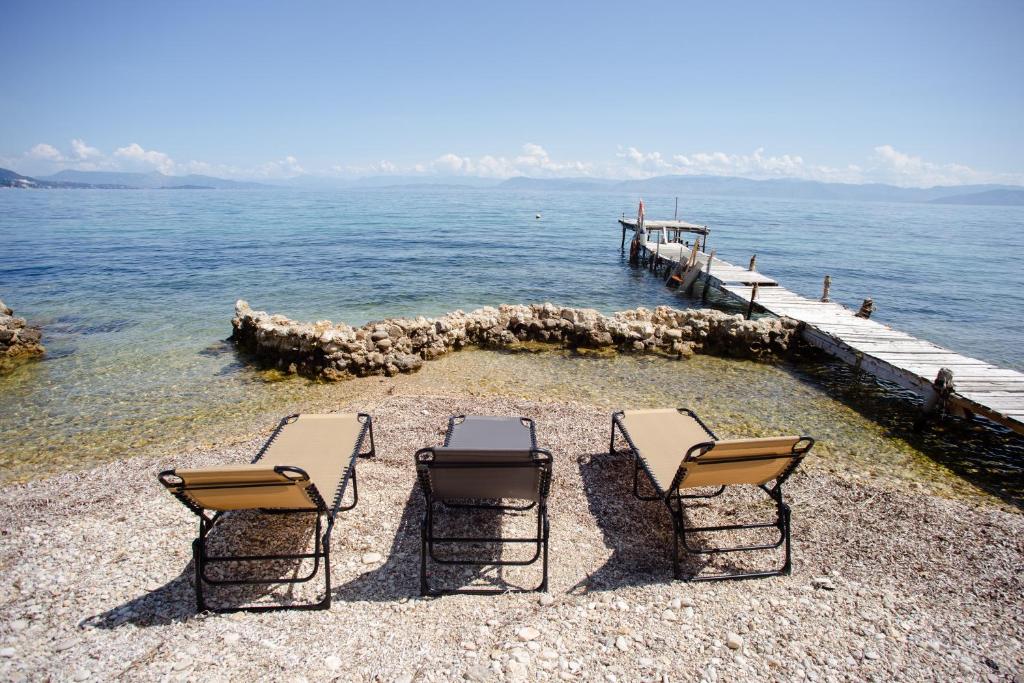 a group of chairs sitting on a beach near the water at Kohyli House in Agia Pelagia Chlomou