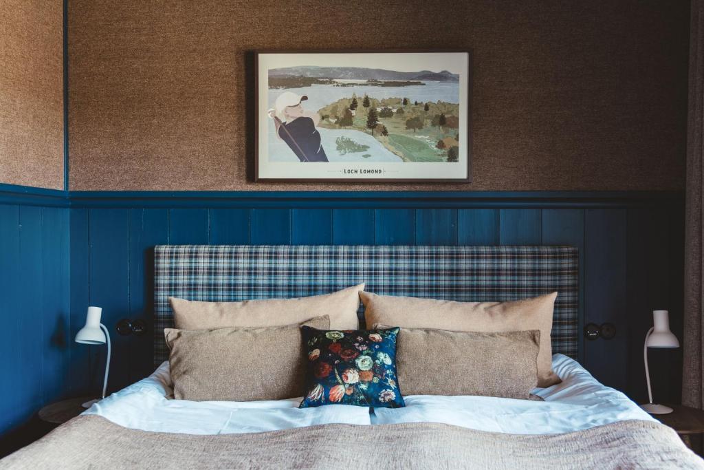 a bedroom with a bed with a blue head board at Tweed Hotell Skaftö in Fiskebäckskil