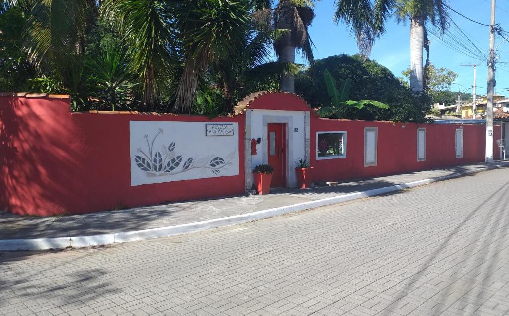 ein rotes Gebäude auf der Straßenseite in der Unterkunft Pousada Vila Magiosa in Búzios